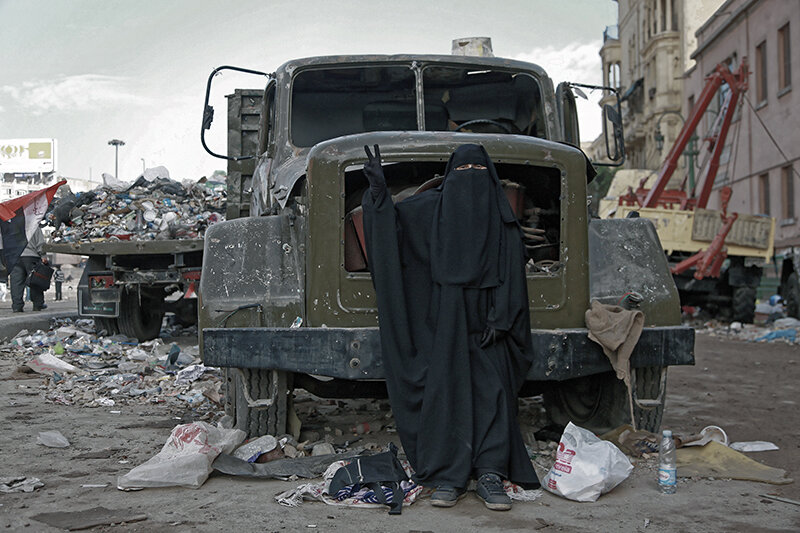Still standing: a niqab-wearing protester flashes a victory sign at the Museum entrance to Tahrir Square, where the toughest battles were fought.