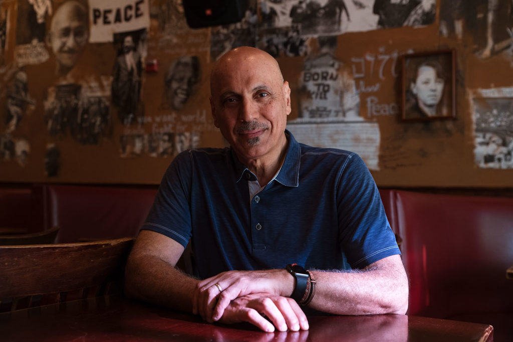 Anas "Andy" Shallal in front of his "Peace and Struggle" mural at the original Busboys and Poets.