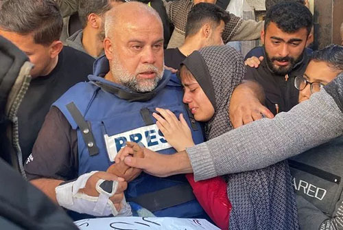 Wael Al-Dahdouh, bureau chief for Al Jazeera in Gaza, hugs his daughter and mourns the killing of his son Hamza by a targeted IDF airstrike. Two weeks earlier, Dahdouh was injured by a missile that killed his cameraman. His wife, two other children, and a grandson were killed in October. Photo: AFP