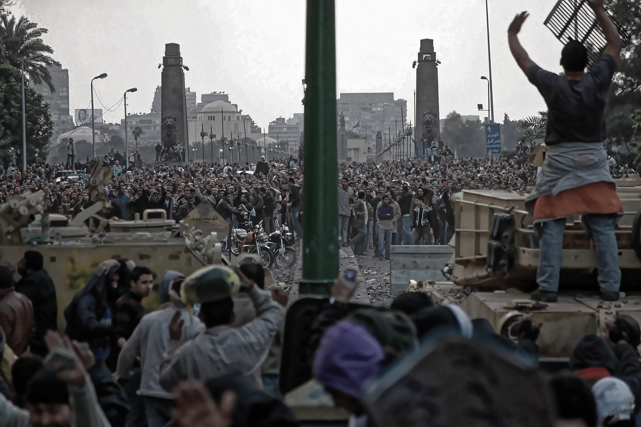 Des défenseurs de la place Tahrir s'abritent derrière des chars d'assaut alors que des partisans de Moubarak lancent des pierres contre eux à l'entrée de la place Qasr el-Nil (toutes les photos sont une courtoisie de Iason Athanasiadis).