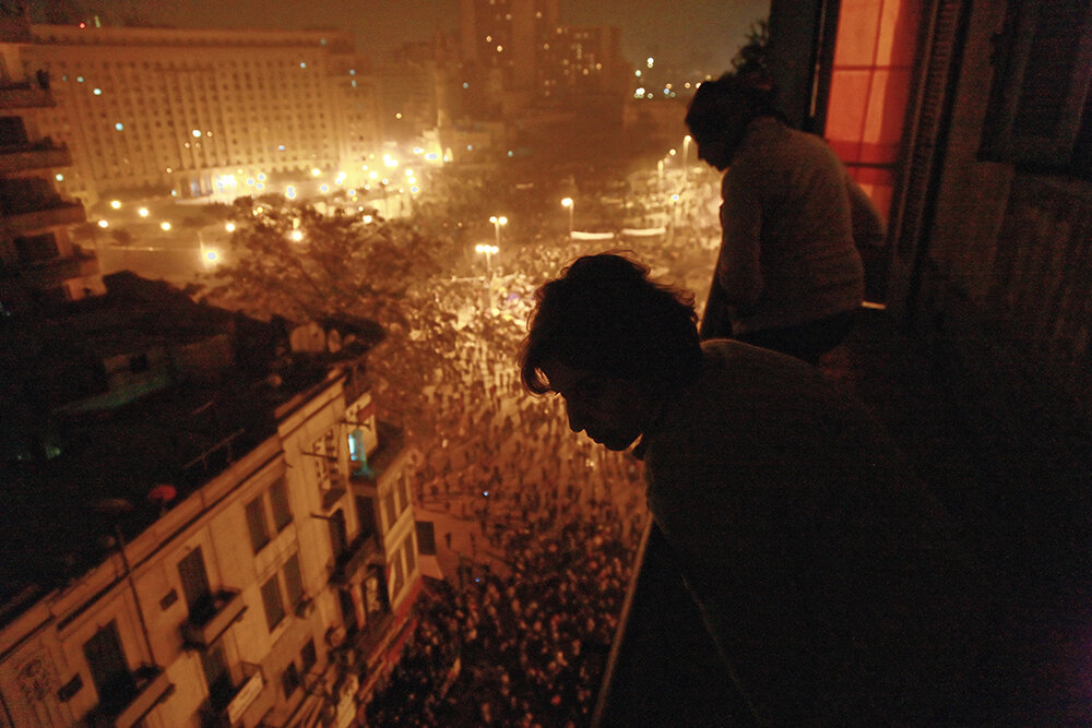 À la tombée de la nuit, des militants, des artistes et des intellectuels suivent le flux et le reflux de la bataille depuis le balcon d'un penthouse surplombant Tahrir.