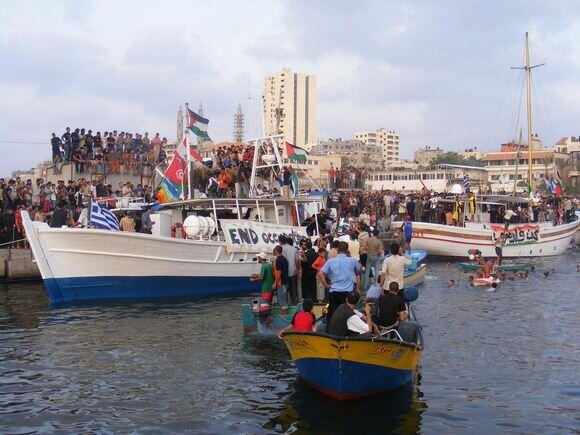 Boats and swimmers welcome the Liberty to the port of Gaza.