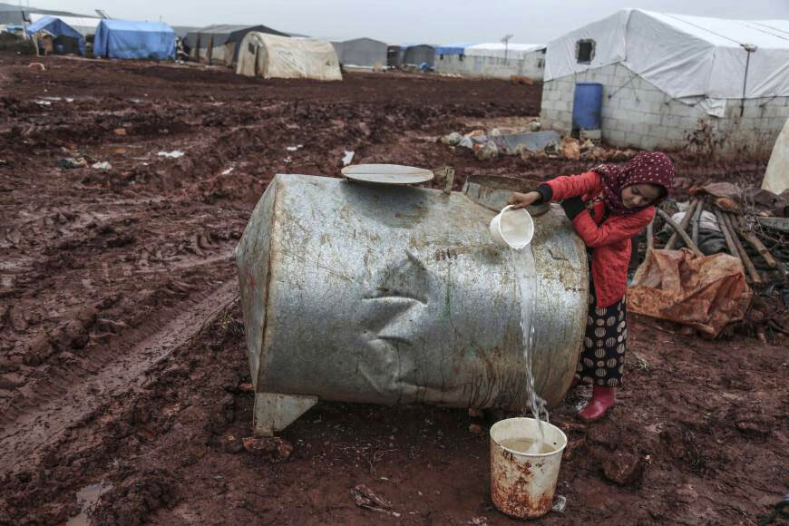 Displaced 11-year-old fills water from a cistern at a camp for displaced Syrians near the Turkish border in the northern countryside of Idlib (Photo: Anas Alkharboutli, AP Images)