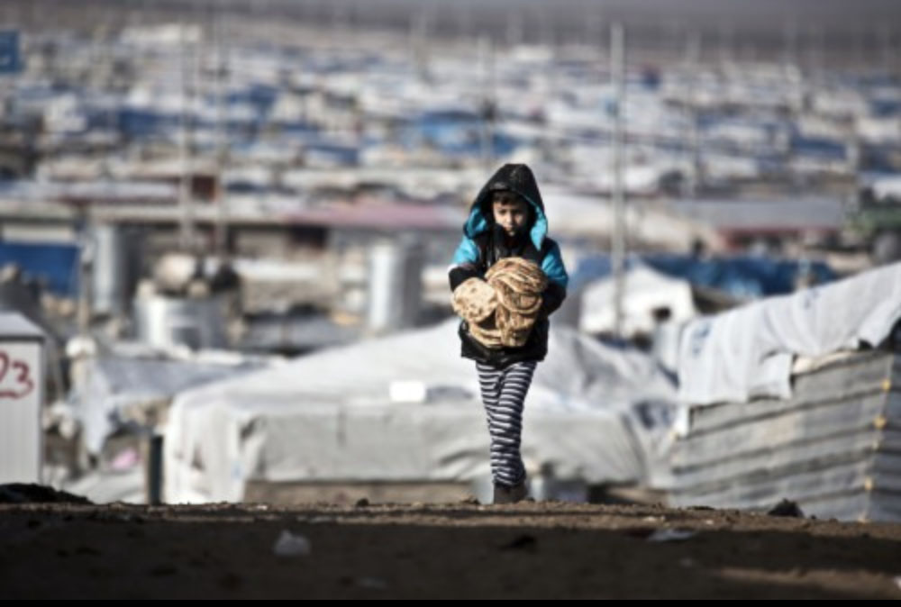 Un garçon syrien porte du pain dans la caravane de sa famille, dans le camp de réfugiés de Zaatari, en Jordanie.
