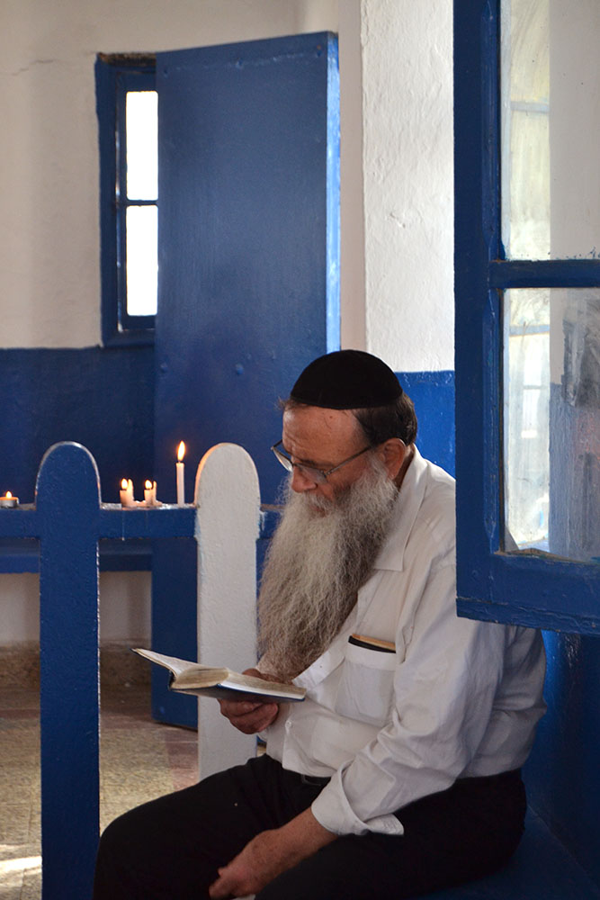 10. Local rabbi reading inside of the Rabbi Slama mausoleum. 