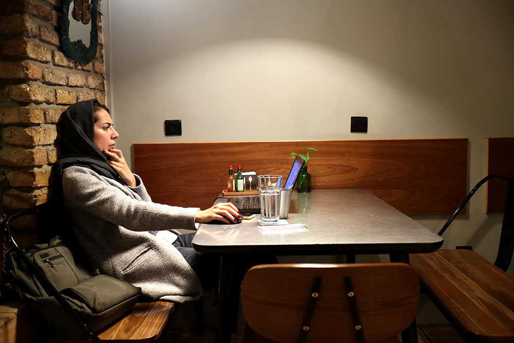 Brains behind the operation. A young woman, who majors in acting and drama in college, in Café UpArtMaan, in central Tehran. 