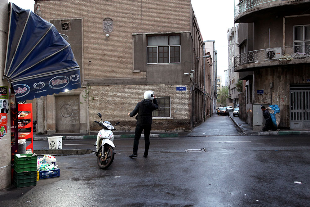 One of the side streets behind Meydan Ferdowsi (Ferdowsi Roundabout, or Square) in central Tehran. The eye is drawn to the motocyclist, although a porter is doing the heavy lifting.