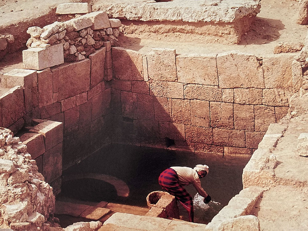 A man wades in the Barbar Temple’s spring following its excavation. The spring has dried out today (photo Ali Al-Jamri)