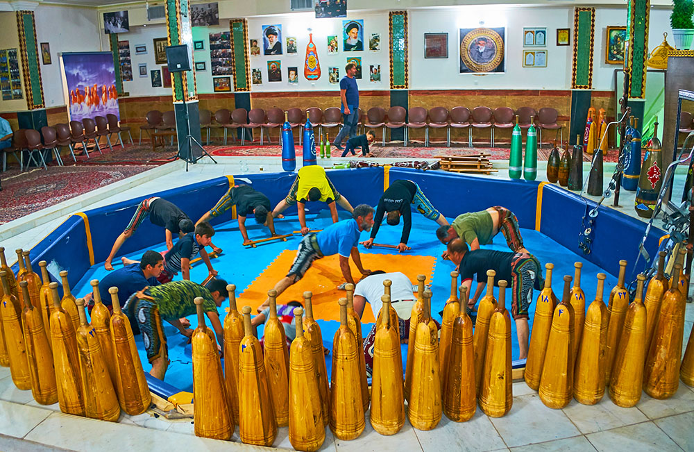 Athletes of different ages and condition train at Zurkhaneh House of Strength doing traditional exercises with drum music Kerman Iran Evgeniy Fesenko.jpg