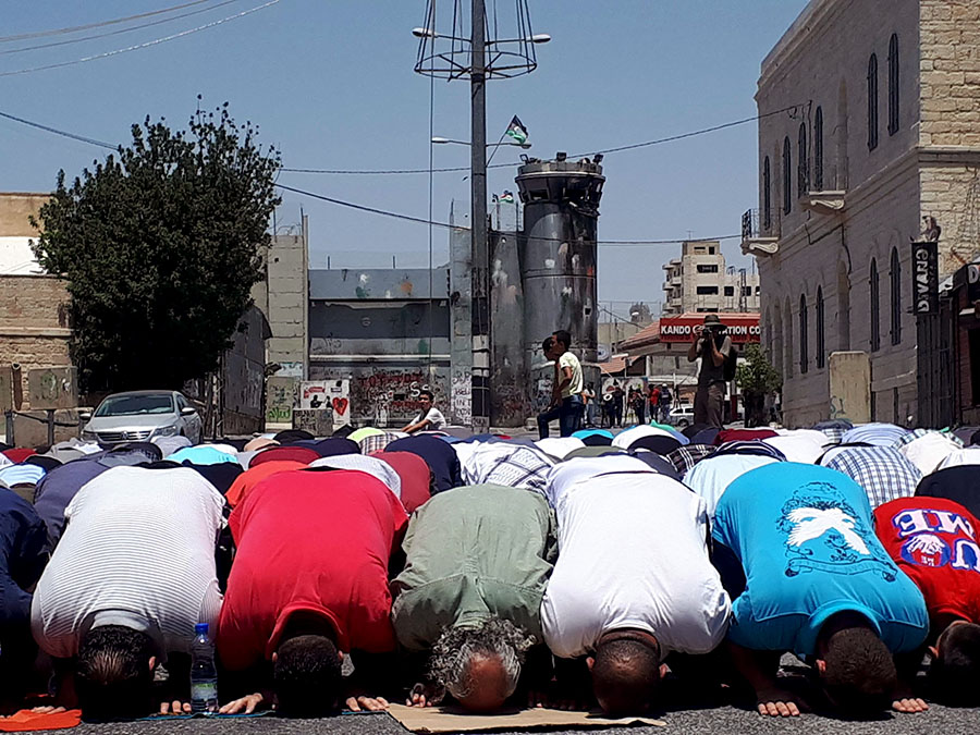 Palestinian protesters pray in front of the Israeli military base on the Jerusalem-Hebron road during the Al-Aqsa camera crisis (Aug 2017).