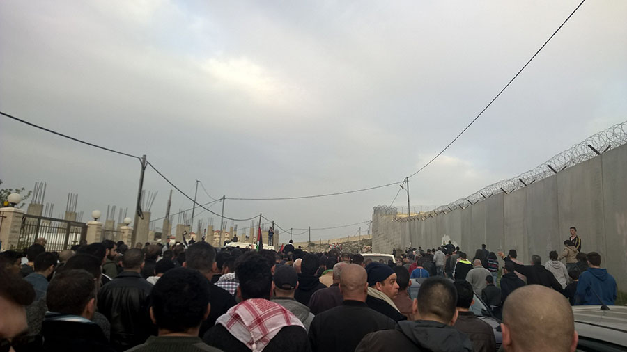 Funeral of Basel al Araj in al-Walaja, with the Har-Gilo settlement behind the separation wall on the right.