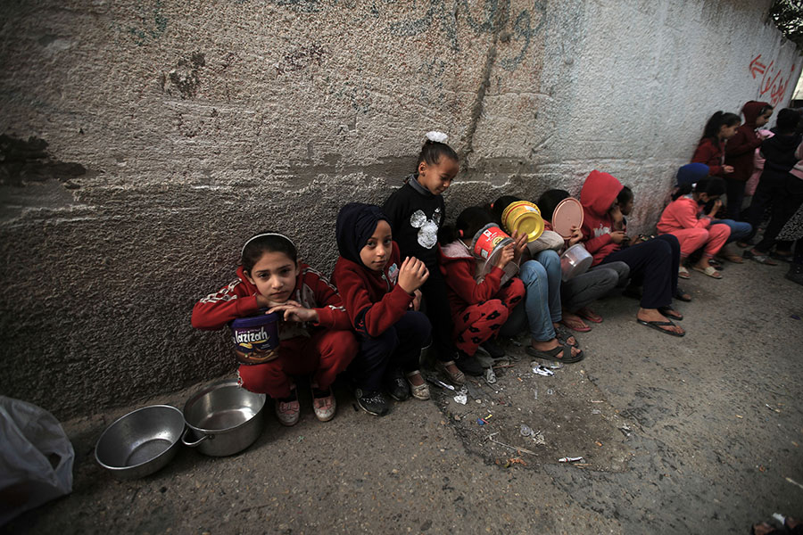 Children in Rafah line up for a meal made by volunteers in late December. Photo: Mohammed Zaanoun/Activestills