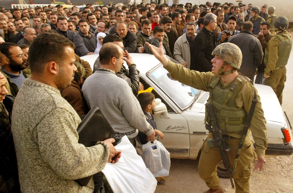 An Israeli soldier directs a group of Palestinians at a closed temporary checkpoint on the outskirts of Nablus on Jan. 29. Abed Omar Qusini Reuters