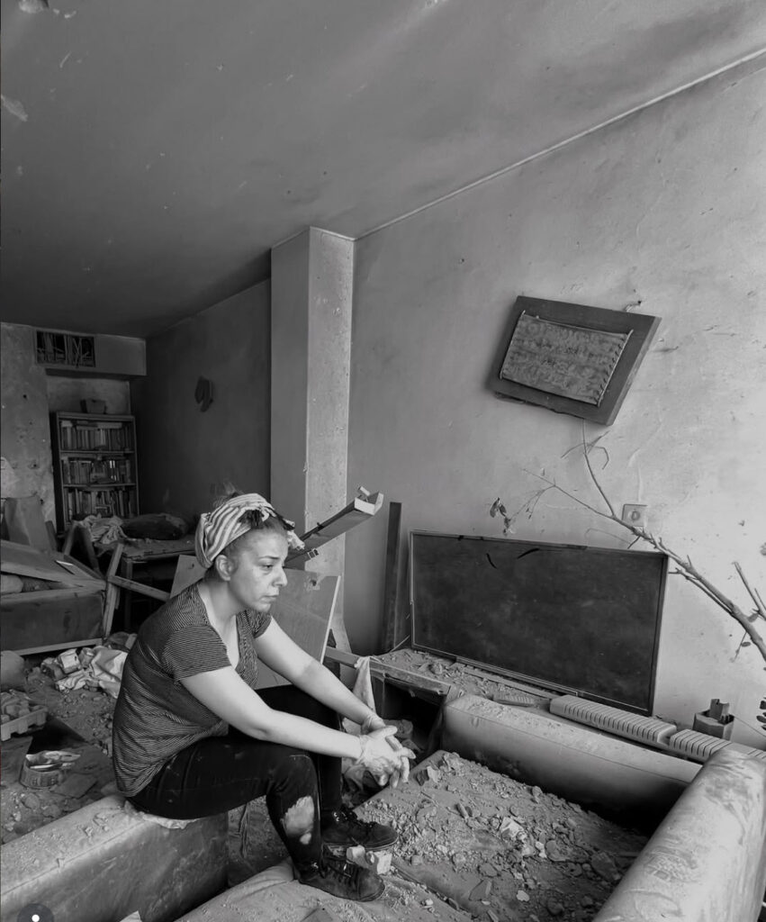 A woman in Tehran sits in the rubble of her flat in the 12 Day War, June 2025 (courtesy Bijan Azimi @bjn.art.photo).
