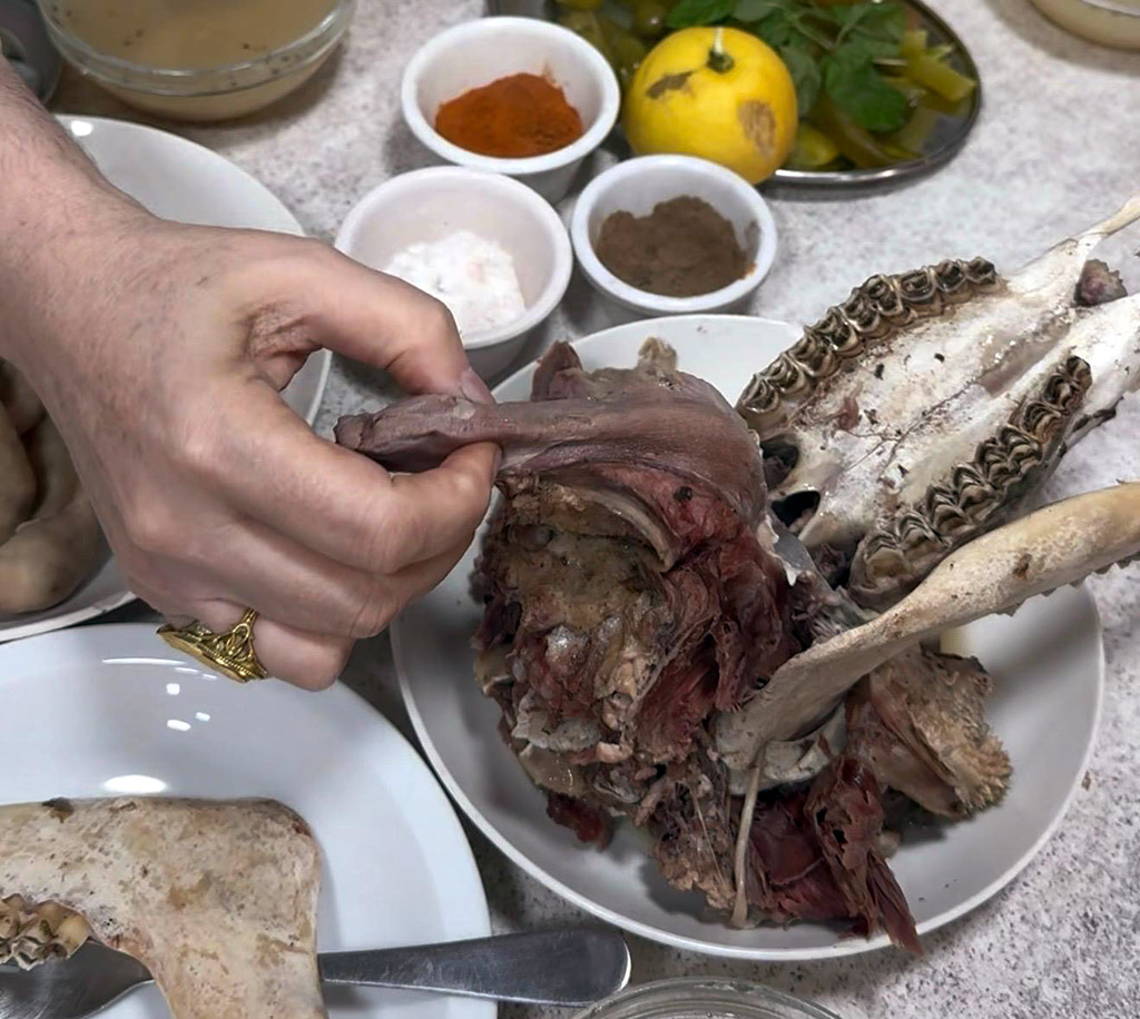 Anissa Helou picking the tongue out of a boiled head