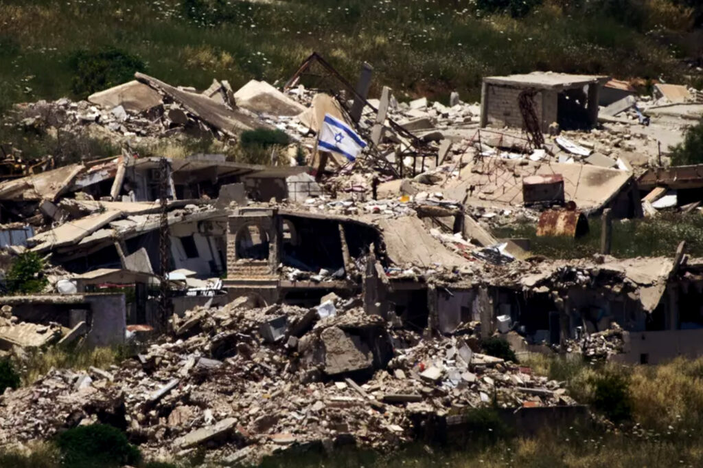 An Israeli flag hangs on a destroyed building in southern Lebanon as seen from northern Israel Thursday June 4 2026 (photo Ariel Schalit AP.jpg