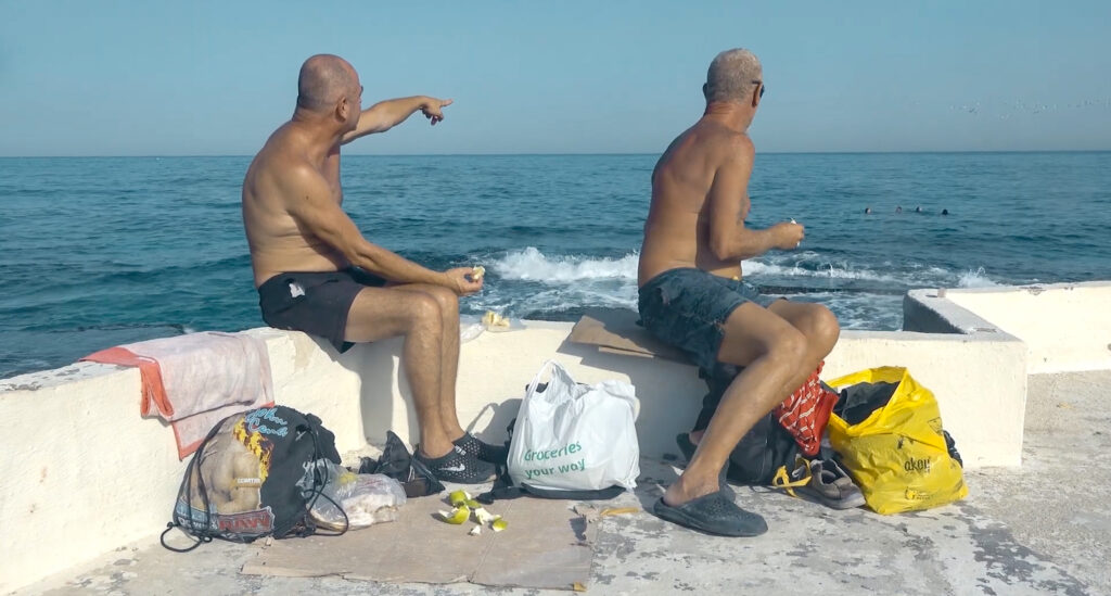Two men watching the sea in Beirut. Still from And the Fish Fly Above our Heads.